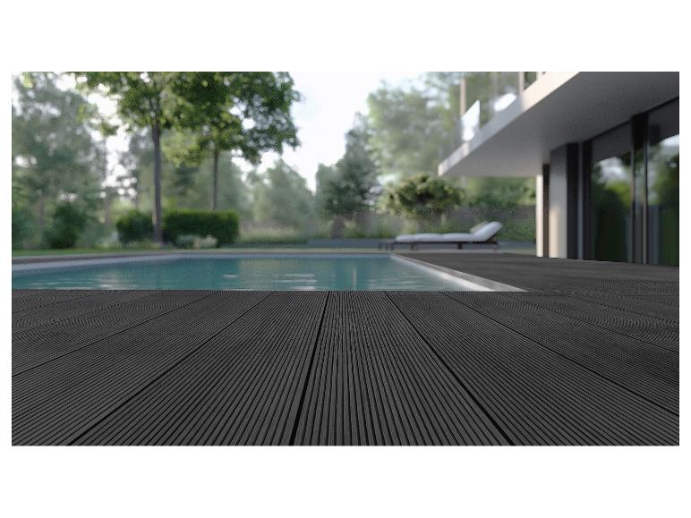 Schwarze Holzterrasse am Pool mit verschwommenem Garten- und Haus-Hintergrund.