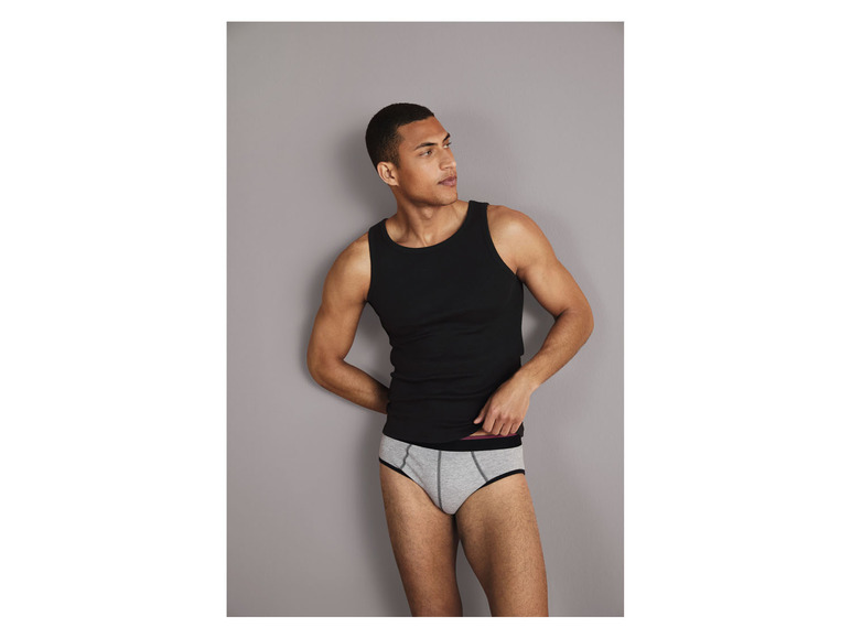 Mann in einem schwarzen Tanktop und grauen Unterhosen.