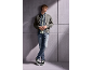 Junger Mann in grauer Jacke, Jeans und Turnschuhen, an eine Wand gelehnt.