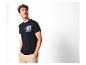 Mann in marineblauem T-Shirt mit Auto- und Palmenprint und beiger Hose.
