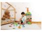 Junge spielt mit Magnetbausteinen und Dinosaurierfiguren auf einer Matte im Kinderzimmer.