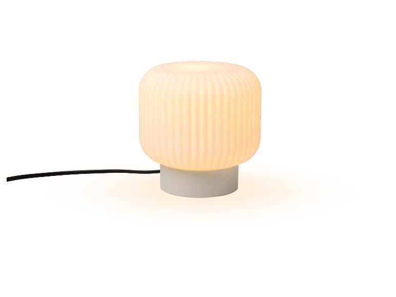 Tischlampe mit weißem Sockel und geripptem, weißem Schirm.