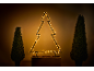 Beleuchtete Weihnachtsbaum-Silhouette mit zwei Topiary-Bäumen in Töpfen.