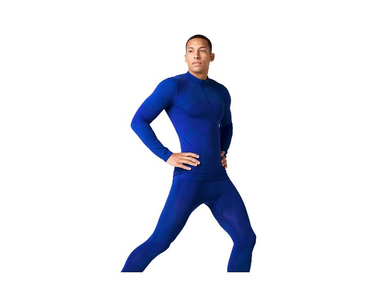 Ein Mann in einem blauen Trainingsset, mit Händen in den Hüften, blickt zur Seite.
