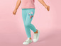 Mädchen in blauen Leggings mit Peppa Pig-Motiv und weißen Sneakern.