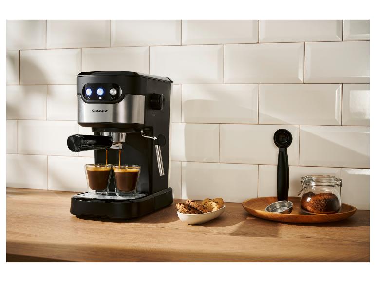 Schwarz-silberne Espressomaschine brüht zwei Tassen Kaffee in einer modernen Küche.