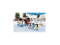 Pinguin-Familien-Spielzeug auf Eis mit Winterlandschaft im Hintergrund.