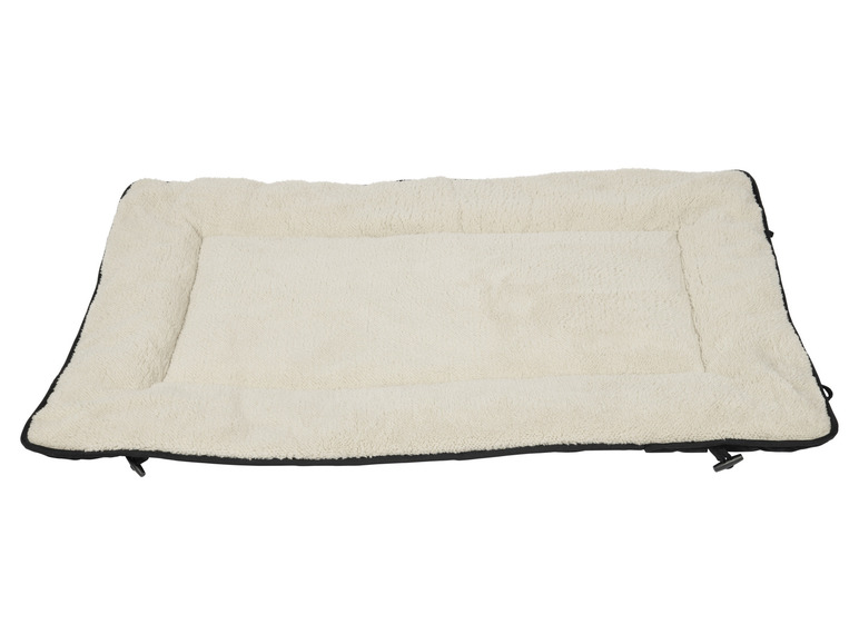 Ein beigefarbenes Hundebett mit schwarzen Rändern.