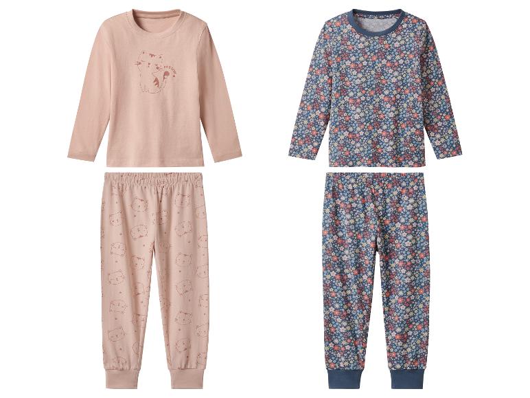 Zwei Kinderpyjamas: einer mit Katzenmotiv und einer mit Blumen.