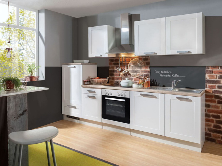 Weiße Küche mit Backofen, Spüle und Oberschränken.