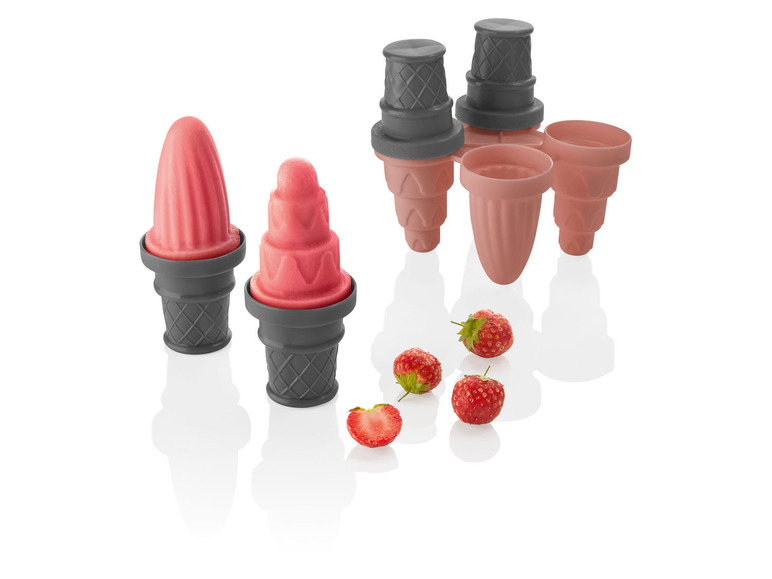 Zwei rosa Eis am Stiel in grauen Waffelhörnchen, neben einem rosafarbenen Eisformen-Set mit Hörnchen.