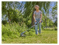 Eine Frau verwendet eine Gardena Akku-Grasschere im Garten.