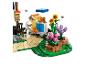 Ein LEGO-Set mit einer Imkerfigur, Bienenstöcken und Blumen, mit fliegenden Bienen.