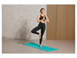 Eine Frau macht Yoga auf einer blauen Matte.