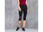 Eine Frau trägt schwarze Capri-Hosen mit rosafarbenen Details für das Training.