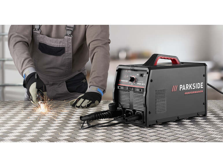 Plasmaschneider auf einem Metalltisch mit Funken während der Arbeit.