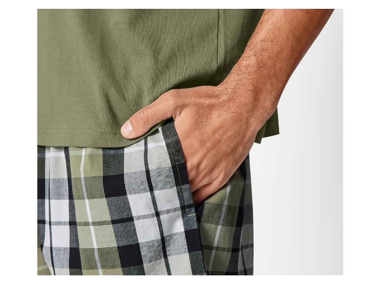 Ein Mann trägt ein grünes T-Shirt und eine karierte Hose.