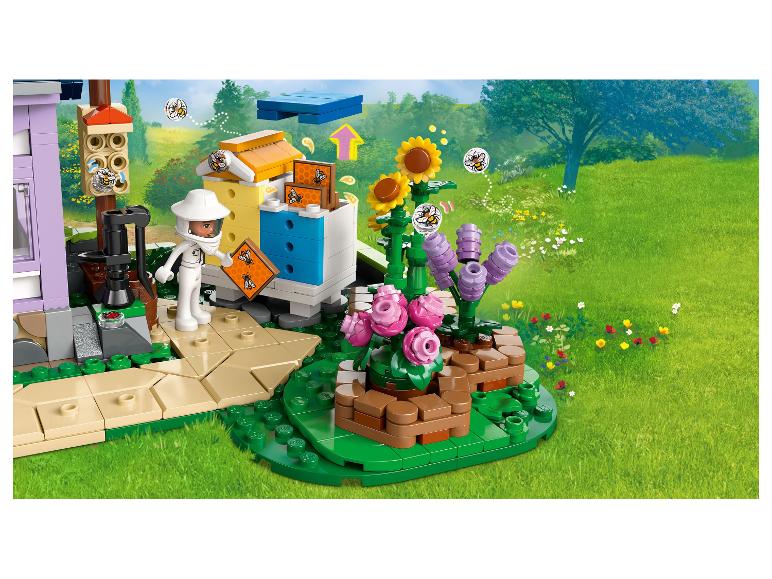 LEGO Friends Set mit Imkerin, Bienenstöcken und Blumen in grüner Landschaft.