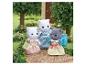 Drei Sylvanian Families Katzenfiguren in Kleidern auf einem Gartenweg.