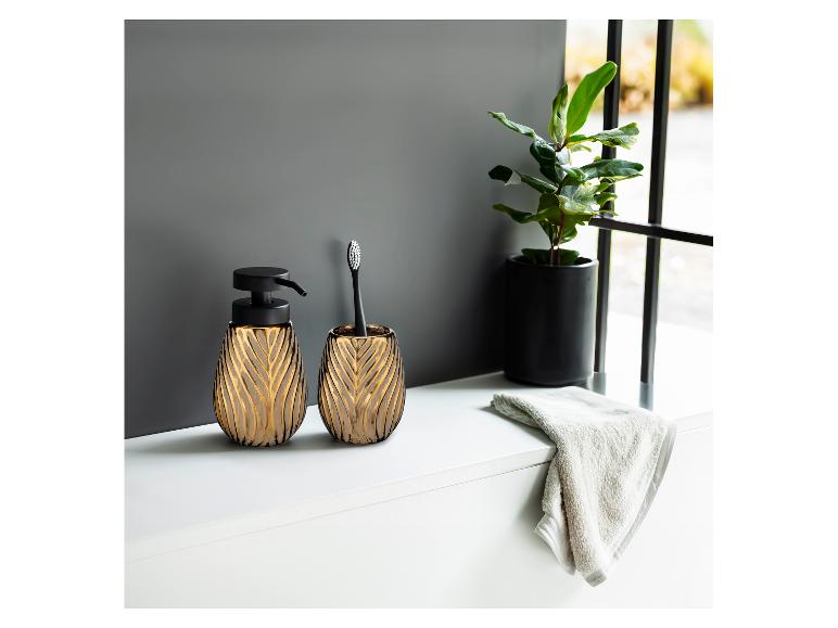 Moderne, elegante Seifenspender und Zahnbürstenhalter in Gold und Schwarz.