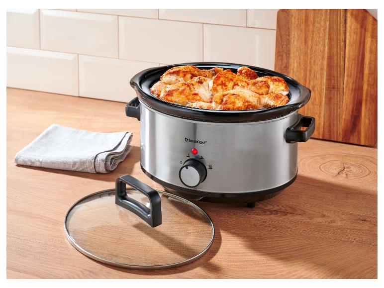 Slow Cooker mit Hähnchen auf einer Holzarbeitsplatte in der Küche.