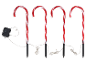 Vier Zuckerstangen-Wegeleuchten mit rot-weißen Streifen, über Kabel mit einer Steuerbox verbunden.