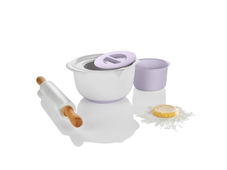 Eine weiße Schüssel, ein Nudelholz und eine kleine Schüssel mit Mehl und Teig.