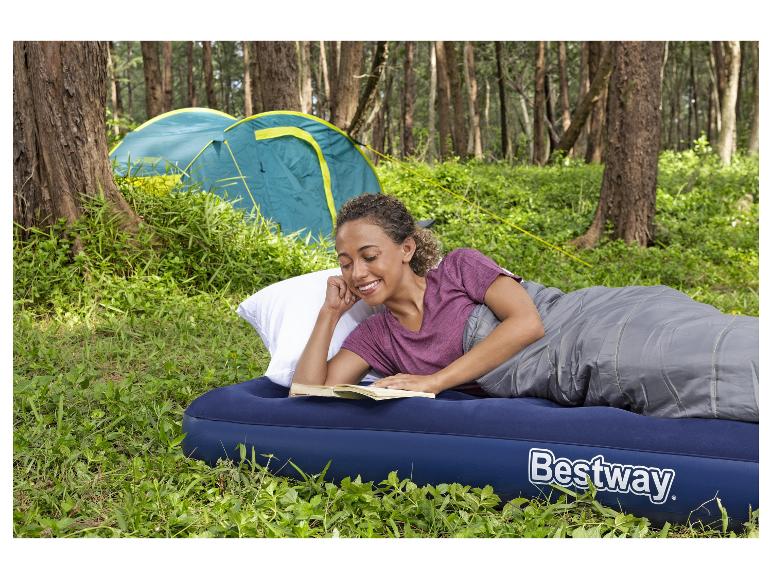 Frau liest auf einer Bestway Luftmatratze mit Schlafsack und Zelt.