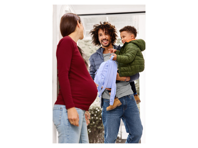 Ein Mann mit seinem Sohn und einer schwangeren Frau an der Tür.