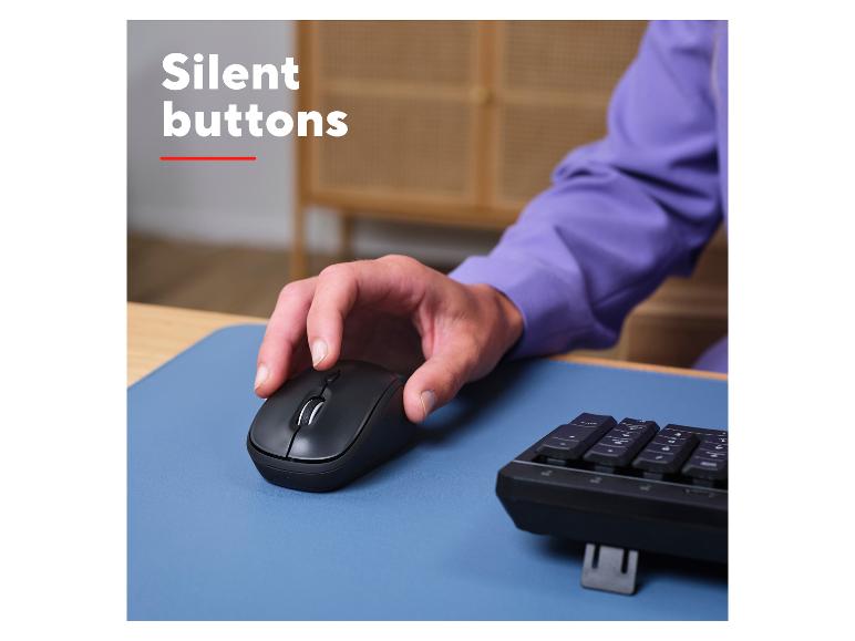 Computermaus mit leisen Tasten, auf einer blauen Unterlage neben einer Tastatur verwendet.