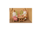 Zwei Hasenfiguren sitzen an einem Holztisch mit einer Obstschale.