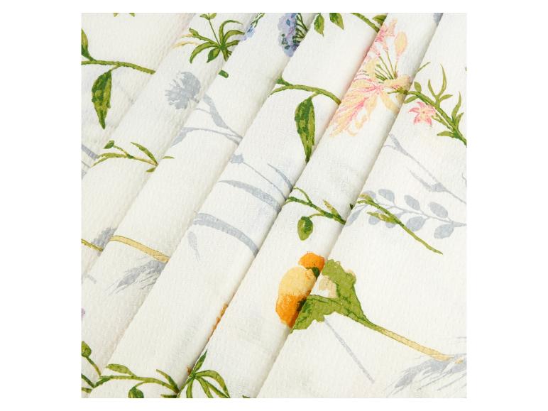 Cremefarbener Stoff mit Blumenmuster, vorwiegend gelbe und rosa Blüten.