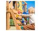 Kind klettert an einer Holzkletterwand mit bunten Griffen auf einem Spielplatz.