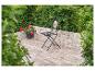 Schwarzer Metall-Gartenstuhl mit Mosaik-Rückenlehne auf einer gepflasterten Terrasse.