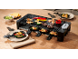 Elektrischer Raclette-Grill mit Speisen auf einem Holztisch.