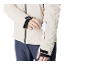 Mann in heller Jacke und dunkelblauer Hose steckt Karte in Ärmeltasche.