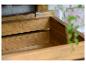 Holzaufbewahrungsbox oder Blumentopf mit Pflanzen im Hintergrund.