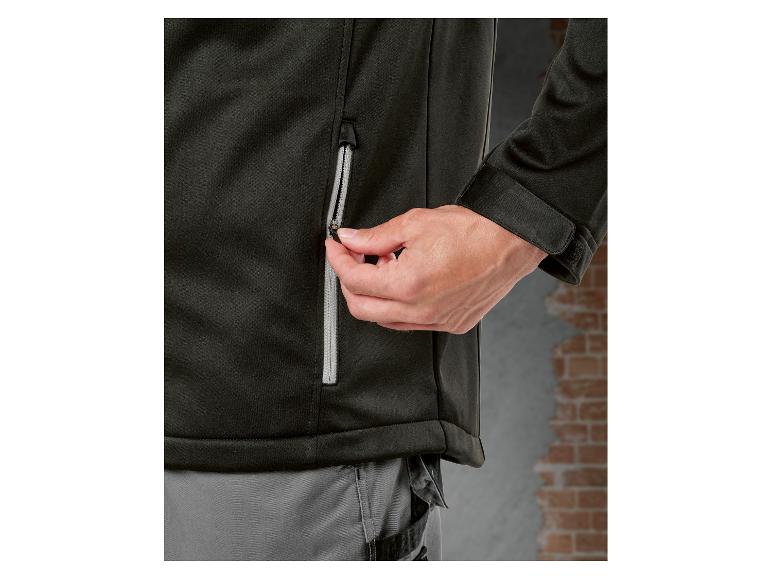 Nahaufnahme einer Person, die eine schwarze Jacke mit Reißverschluss schließt.