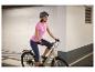 Frau auf E-Bike mit Helm und Sportkleidung.