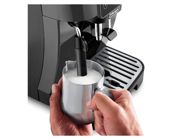 Schwarze De'Longhi Kaffeemaschine, bei der eine Person Milch in einem Metallkännchen aufschäumt