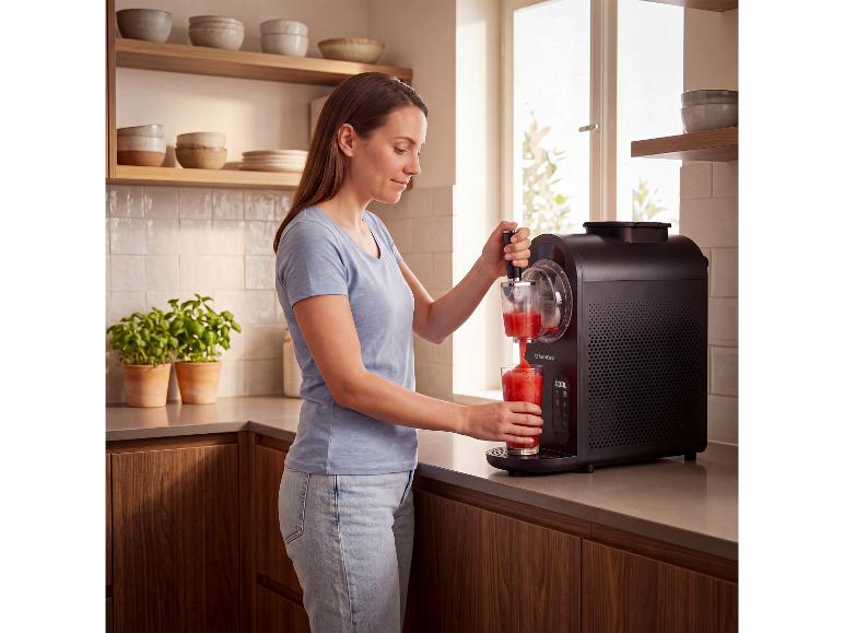 Frau bereitet mit der SILVERCREST® 3-in-1-Maschine ein rotes Slushy in der Küche zu.
