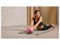 Eine Frau trainiert mit einem rosa Fitnessball von Crivit auf einer Yogamatte.
