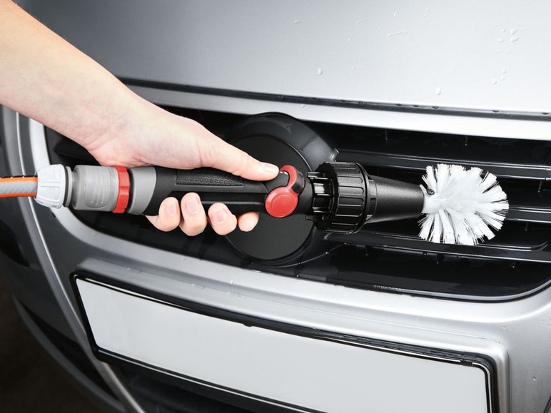 Eine Hand hält eine Kärcher-Bürste zum Reinigen eines Autos.