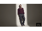 Mann in weinrotem V-Ausschnitt-Pullover und grauer Hose.