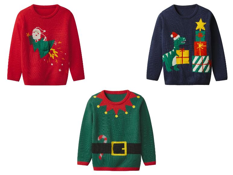 Drei Weihnachtspullover: ein roter mit Weihnachtsmann auf Rakete, ein blauer mit Dinosaurier und Geschenken, ein grüner Elfenpullover.