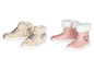 Zwei Paar Mädchen-Stiefel: beige mit Sternen und rosa mit Katzenmotiv.