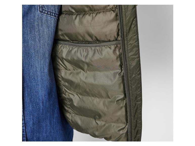 Detail einer grünen, gesteppten Jacke kombiniert mit Jeans.