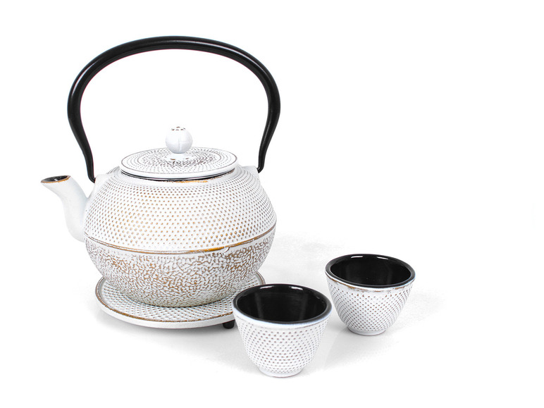 Weißer Gusseisen-Teekanne mit zwei Tassen.