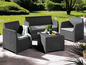 Eine Lounge-Garnitur mit zwei Sesseln, einem Sofa und einem Couchtisch in einem Garten.