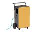 Gelb-schwarzer Luftentfeuchter auf Rädern mit angeschlossenem blauem Schlauch.